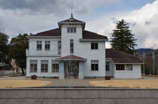 青年幹部養成学校などとして使われた西洋館。塔を中央に、左右非対称の建築様式。手前の噴水泉とともに国登録有形文化財。